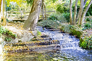 River-stream passing through Parque del Oeste, Madrid park with some autumn colors on a clear day in Madrid, Spain. photo