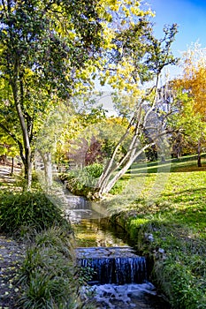 River-stream passing through Parque del Oeste, Madrid park with some autumn colors on a clear day in Madrid, Spain. photo