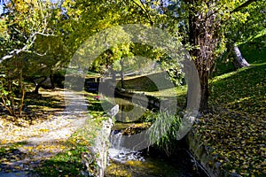 River-stream passing through Parque del Oeste, Madrid park with some autumn colors on a clear day in Madrid, Spain. photo
