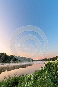 River at sunrise. the mist over the water. the vertical frame. in the sky you can see the plane