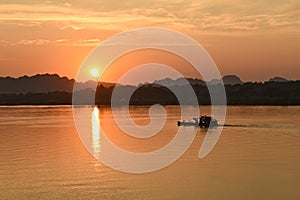 River sunset with a fisher boat and mountains