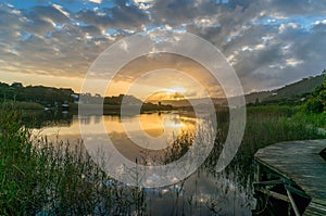 River sunset landscape with beautiful clouds, water reflection