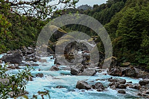 River surrounded by rocks and greenery in the Queulat National Park, Chile photo