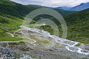 River system of norwegian glacier Steindalsbreen meanders in a green valley