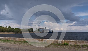 River terminal-elevator on the bank of the Kremenchug reservoir against a blue sky background, the village of Vitovo