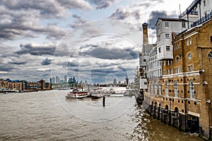 River Thames With Boats And Docks Beneath Butler\'s Wharf From Tower Bridge In London, UK