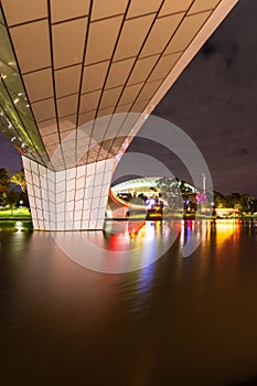 A Foot Bridge crossing a river and Sports Stadium at Night photo
