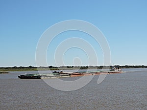 River Tug - Pusher `ASUNCION` and convoy of bardes loaded in navigation along of the Water Way Hidrovia rivers Paraguay Parana photo