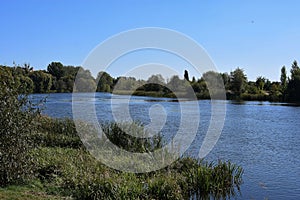 River between two banks on blue sky background