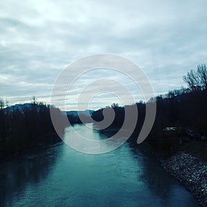 River under a cloudy sky with mountains