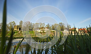 River Venta, grass and historical houses in sunny spring day, Kuldiga, Latvia