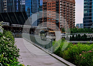 River walk ramp leading up to Wacker Drive with elevated `el` trains crossing over Chicago River. photo