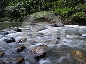 River water flows through the rocks in the morning photo