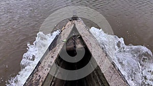 River water passing by under wooden boat stem