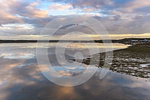 Late afternoon river waterscape with cloud reflections photo