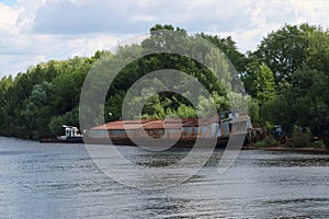 River watrer, lonely rusty cargo ship dire straits