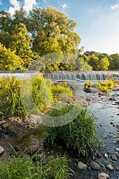 A river weir with trees late afternoon
