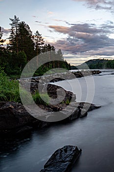 River in the wilderness next to a forest area at dusk in Norrland photo