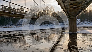 A river in winter, in the backlight of the bridge structure