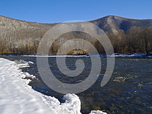 The river in the winter at a mountain slope