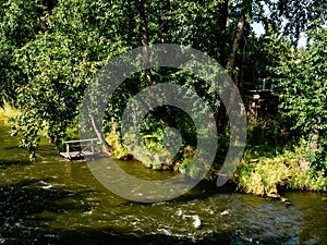 River with a wooden pier and a small house