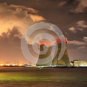 Riverbank with nuclear power plant Doel at night with dramatic clouds, Port of Antwerp