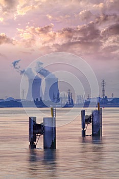 Riverbank with nuclear power plant Doel during a sunset with dramatic cluds, Port of Antwerp photo