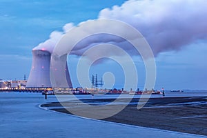 Riverbank with nuclear power plant at twilight
