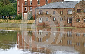 Riverside flats reflected in water at high tide.