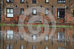 Riverside flats reflected in water at high tide.