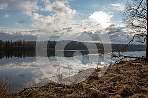 riverside landscape in latvia with dark water and dirty shore line