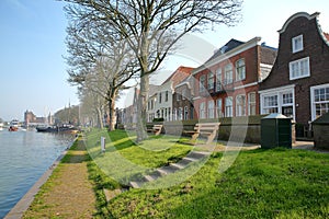 The riverside of Muiden with traditional houses and Muiderslot Castle in the background, Muiden