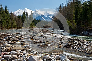 Riverside stones on Bialka river near Jurgow, Malopolskie, Poland in spring. In the background snow covered peaks. photo