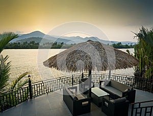 Riverside sunset view in kampot cambodia asia with deck sofas photo