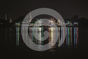 Riverside thai local temple is decorated with different color fireworks in the full moon festval