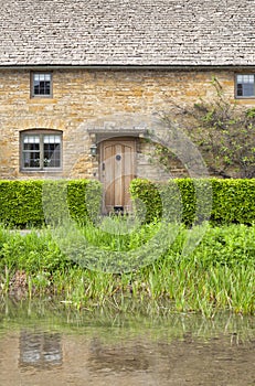 Riverside traditional stone home with garden hedge