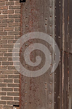 Riveted steel corner with heavy rust patina, brown brick, copy space