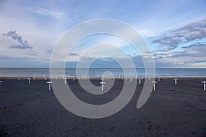 Riviera Romagnola beach near Rimini and Riccione, with typical umbrella supports; nobody; desolation mood