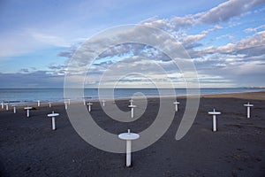 Riviera Romagnola beach near Rimini and Riccione, with typical umbrella supports; nobody; desolation mood