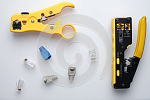 RJ45 twisted pair pair crimper and stripper with cable connectors on white background