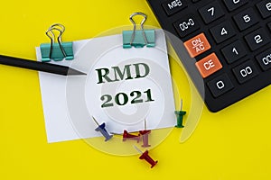 RMD - acronym on a white sheet with clips on a yellow background with a calculator, buttons and pencil