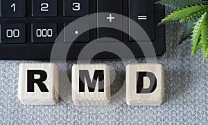 RMD - acronym on wooden cubes on a gray background with a calculator photo