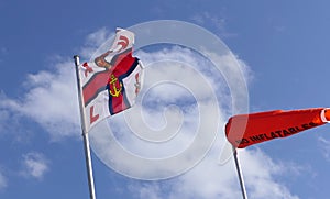 RNLI Flag and Orange windsock and Beach Warning Flags indicating sea hazard on sandy beach in UK