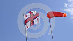 RNLI Flag and Orange windsock and Beach Warning Flags indicating sea hazard on sandy beach in UK
