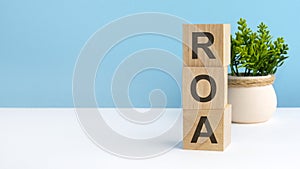 ROA - acronym from wooden blocks with letters, blue background. copy space available