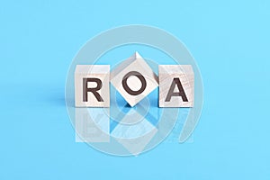 ROA - acronym from wooden blocks with letters, front view on blue background