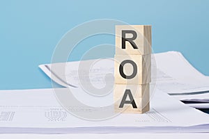 ROA - financial concept. wooden cubes on blue background