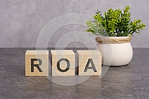 the ROA letters is written on wooden cubes on a gray background. close-up of wooden elements. In the black background is