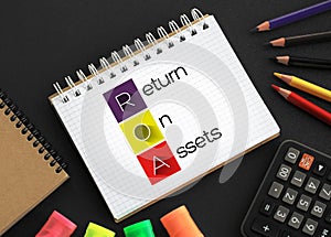 ROA - Return On Assets acronym on notepad, business concept background