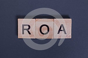 ROA Return On Assets from wooden letters on a gray background